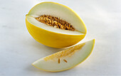 Honeydew melon, one slice cut out, on a light background