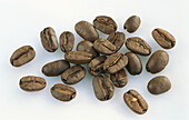 Several coffee beans on a light background