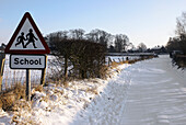 School warning sign on snowy road