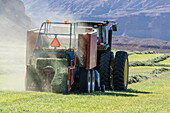 Baling hay on a ranch with a tractor and baler