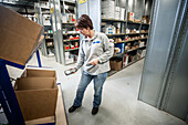 Woman scanning boxes in a warehouse