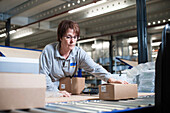Woman packaging a client's order in a warehouse