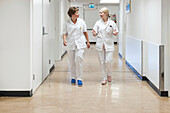Two nurses walking down the corridor of a nursing ward