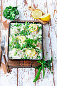 Fish fillet baked with green peas and cream