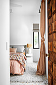 Blick ins Schlafzimmer mit terrakottafarbenen und grauen Accessoires