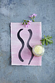 Gemaltes Zeichen auf rosa papier und Tiegel mit Creme (Duft für die Nerven)