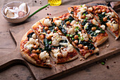 Vegan spelt pizza with cauliflower, chickpeas, and spinach