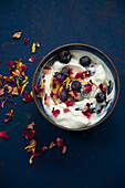 Joghurt mit Heidelbeeren und essbaren Blüten