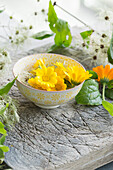 Flower bowl filled with marigolds (Calendula officinalis) and clematis vines