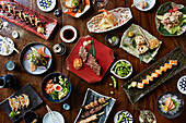 Auswahl an japanischen Gerichten: Sushi, Terayki-Spieße und Gyoza