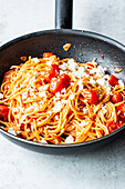 Simple spaghetti 'aglio e olio' with tomatoes and feta