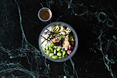 A healthy bowl with rice, tuna, avocado and edamame to take away