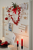 Christmas-decorated memo board and red candles