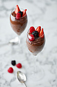 Chocolate mousse topped with strawberries and raspberries served in a champagne glass