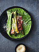 Spinach pancakes with green asparagus and Parma ham
