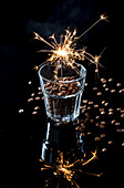 A sparkler in a glass of coffee beans