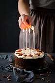 Candles on a carrot cake being lit