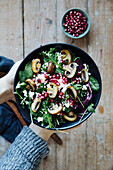 Lukewarm winter salad with mushrooms, feta, pomegranate seeds, and rocket