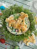 Easter bunnies made of puff pastry, in a salad wreath