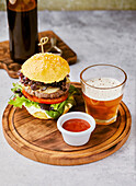 Cheeseburger mit karamellisierten Zwiebeln serviert mit einem Glas Bier