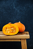 Hokkaido pumpkin, halved on a wooden bench