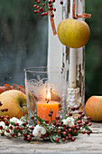 Small wreath of snowberries, rosehips and heather around a candle