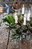 Adventsgesteck mit Kerzen und Frühlingsblumen auf Holztisch