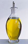 Eine Flasche Olivenöl auf hellem Untergrund