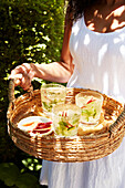 Girl holding a tray of drinks in the summer sun