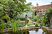 Natural pool surrounded by tree trunks in the garden