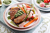 Roast duck breast with rocket pesto and spring vegetables