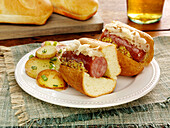 Sandwich mit polnischer Wurst, Sauerkraut und körnigem Senf, dazu Bratkartoffeln