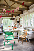 Bright studio with bunting, chandelier and colorful chairs