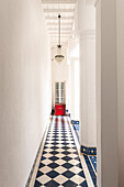 Corridor with black and white checkerboard pattern and chandelier