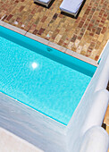 Swimming pool with turquoise blue water and terracotta tiled edge