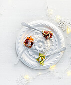 Weihnachtshappen auf dekorativem Teller mit Feige, Spargel und Lachs