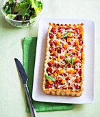 Rectangular tarte with tomatoes, cheese, and mint