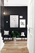 Hallway with dark wall, parquet flooring, artwork and seating area