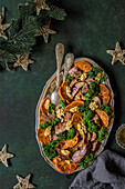 Weihnachtlicher Salat mit Kaki, Grünkohl, Walnüssen und gebratenem Truthahn