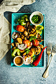 Gesunder Salat aus gegrilltem Bio-Gemüse, serviert mit Kräutern und Walnusssauce