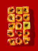 Apples, cut into cubes, on a red background