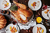 Thanksgiving table spread with a large turkey, chestnuts and mustard