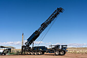 Telescoping truck-mounted workover rig folding up