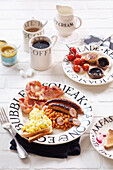 Englisches Frühstück mit Würstchen, Baked Beans, Toast, Rührei und Bacon