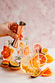 Making a blood orange cocktail with prosecco and passion fruit