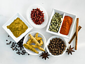 Various spices in small bowls on a light background