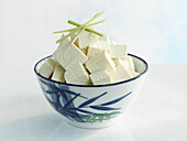 Tofu cubes in an Asian bowl on a light background