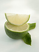Half of a lime and slice of lime with leaves