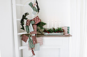 DIY-Kerzenschale zum Advent, daneben aufgehängte Päckchen