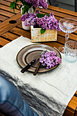 Spring place setting with lilac flowers on outdoor table